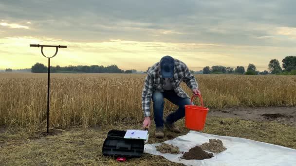 Специалист Агрономии Выливает Образец Почвы Ведра Основание Делая Заметки Отборе — стоковое видео