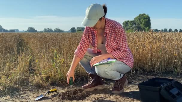 Female Agriculturist Measuring Soil Features Using Soil Tester Writing Data — Vídeo de Stock