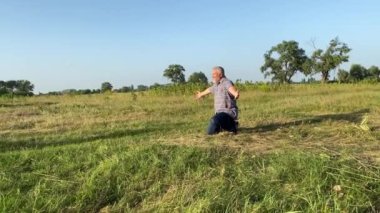 Father cuddling children while having leisure at nature sunset. Family with two children spending time together outdoors. Little boy and girl embracing grandpa at meadow. Happiness in simply living