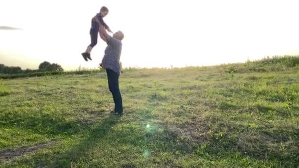 Silhouette Man Throwing Little Boy High Gold Lights Summer Sun — Vídeos de Stock