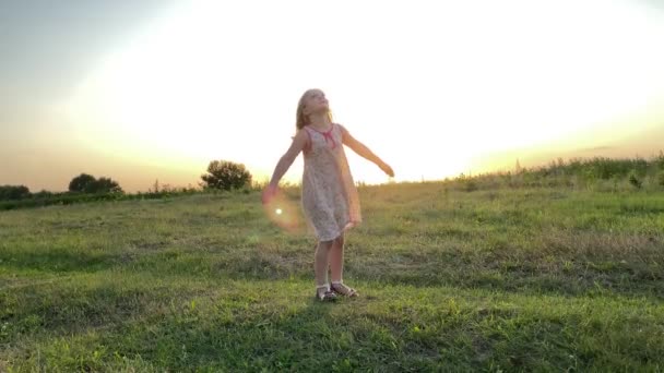 Чарівна Маленька Дівчинка Кружляє Навколо Золотих Вогнях Літнього Заходу Сонця — стокове відео