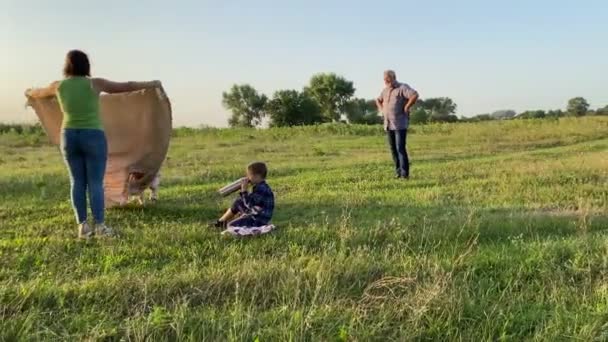 Familj Med Två Barn Som Förbereder Picknick Utomhus Vid Solnedgången — Stockvideo