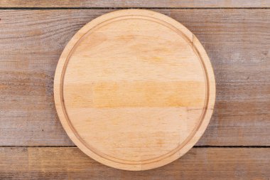 Tahta arka planda yuvarlak şekilli boş kesme tahtası. Üst Manzara. Metin için boşluk.