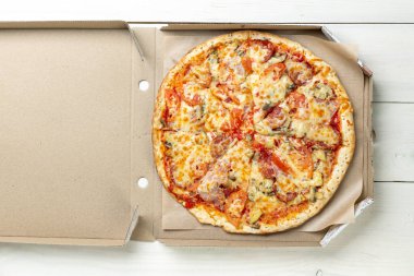 Beyaz arka planda karton bir kutuda pizza. Mesaj için yer var. Yukarıdan bak. Pizza teslimatı Pizza menüsü.