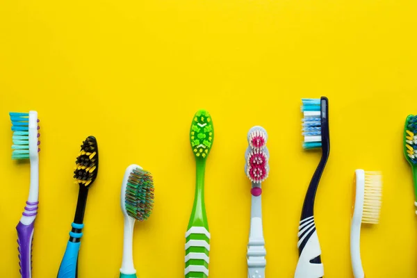 Toothbrushes on a yellow background. Health care, dental hygiene. Space for text. Top view.