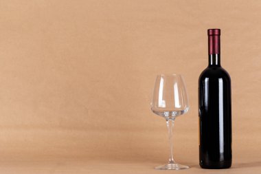 Kırmızı şarap şişesi ve arka planda cam..