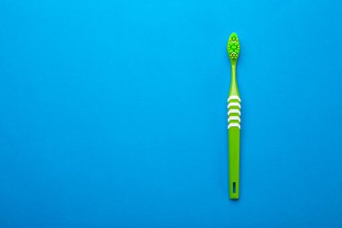 Mavi arka planda diş fırçası. Sağlık hizmeti, diş hijyeni. Mesaj için yer var. Üst görünüm.