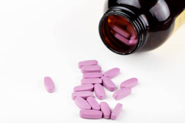 İlaç şişesinden dökülen pembe ilaç ve haplar. Antidepresan ilaçlar. Metin için boşluk.