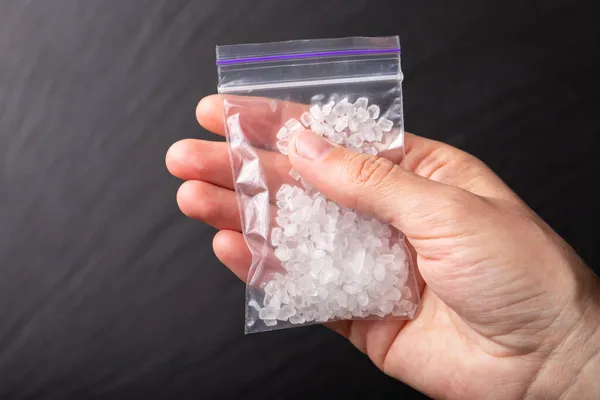 Άνθρωπος Χέρι Κρατά Λευκά Κρύσταλλα Ναρκωτικά Μεθαμφεταμίνη Μια Πλαστική Σακούλα — Φωτογραφία Αρχείου