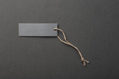 İple bağlanmış boş bir etiket. Fiyat etiketi, hediye etiketi, satış etiketi, gri arka planda izole edilmiş adres etiketi. Mesaj için yer var. Üst görünüm.