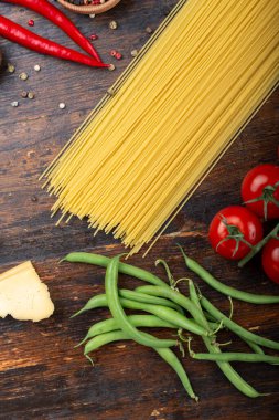 Spagetti ve içindekiler eski ve eski bir ahşap masada. İtalyan mutfağı. Lezzetli yemek..