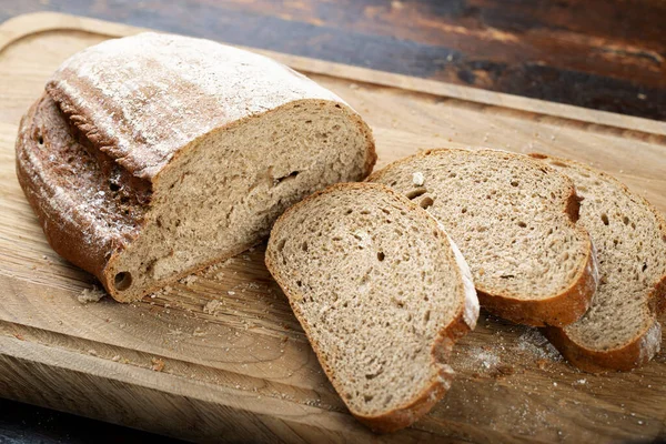 Κομμένο Ψωμί Ένα Ξύλο Κοπής Κομμάτια Ψωμιού Και Ψίχουλα — Φωτογραφία Αρχείου