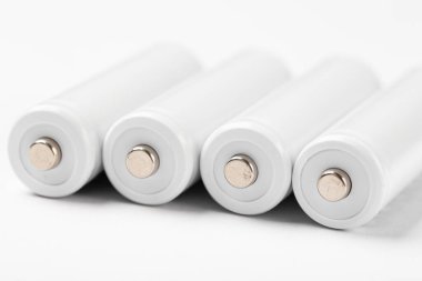 Beyaz arka planda AA büyüklüğünde alkalin piller. Peş peşe birkaç pil. Metin için boşluk.