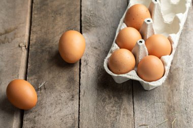 Kutuda taze organik tavuk yumurtası ya da ahşap arka planda yumurta kabı. Çiftçilik ve tarım kavramı. Metin için boşluk.