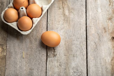 Kutuda taze organik tavuk yumurtası ya da ahşap arka planda yumurta kabı. Çiftçilik ve tarım kavramı. Metin için boşluk.