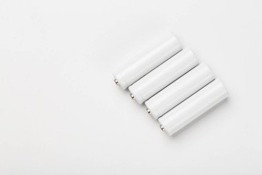 Beyaz arka planda AA büyüklüğünde alkalin piller. Peş peşe birkaç pil. Metin için boşluk.