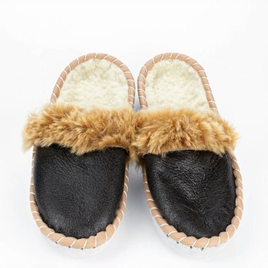 Beyaz arka planda sıcak terlikler. Gerçek deriden yapılmış ev ayakkabıları..