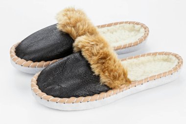 Beyaz arka planda sıcak terlikler. Gerçek deriden yapılmış ev ayakkabıları..