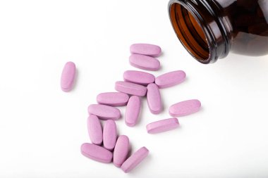İlaç şişesinden dökülen pembe ilaç ve haplar. Antidepresan ilaçlar. Metin için boşluk.