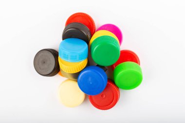 Beyaz arka planda renkli plastik kaplama yığını. Geri dönüşüm konsepti. Plastik şişe kapaklarını geri dönüşüm ve işleme.