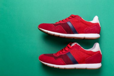 Yeşil arka planda yeni markasız koşu ayakkabısı ya da antrenör. Erkek spor ayakkabıları. Bir çift spor ayakkabı. Metin için boşluk.