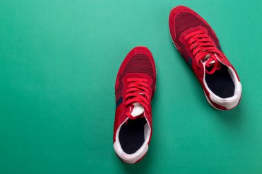 Yeşil arka planda yeni markasız koşu ayakkabısı ya da antrenör. Erkek spor ayakkabıları. Bir çift spor ayakkabı. Metin için boşluk.