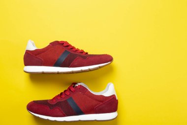 Sarı arka planda yeni markasız koşu ayakkabısı ya da antrenör. Erkek spor ayakkabıları. Bir çift spor ayakkabı.