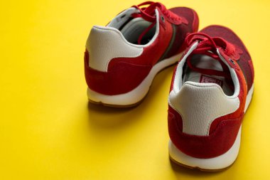 Sarı arka planda yeni markasız koşu ayakkabısı ya da antrenör. Erkek spor ayakkabıları. Bir çift spor ayakkabı.