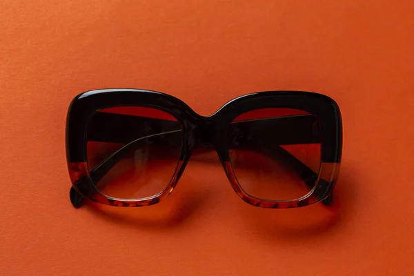 Schwarze Sonnenbrille Auf Orangefarbenem Hintergrund Draufsicht Flache Lage Minimalistisches Konzept — Stockfoto