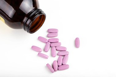 İlaç şişesinden dökülen pembe ilaç ve haplar. Antidepresan ilaçlar. Metin için boşluk.
