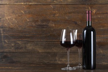 Ahşap arka planda şarap şişesi ve iki bardak. Metin için Soace.