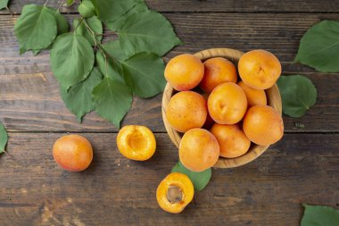 Masanın üzerindeki kil kasede leziz olgun kayısılar. Sağlıklı meyve.