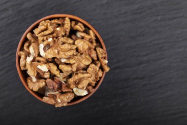 Kil kasede ceviz, siyah zemin üzerinde kopya alanı. Üst görünüm. 