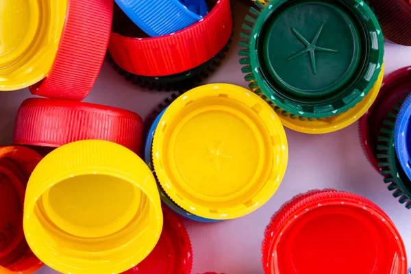Plastic bottle caps background. Cap material is recyclable. Recycling collection and processing plastic bottle caps. Remove lids from plastic bottles before recycling them.