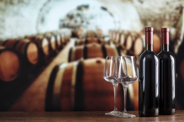 Şarap şişesi ve gözlüklü şarap mahzeni. Şarap mahzeninde kırmızı şarap tatma. Metin için boşluk ile.