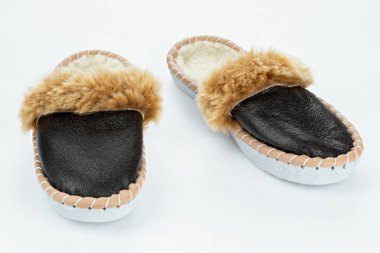 Beyaz arka planda sıcak terlikler. Gerçek deriden yapılmış ev ayakkabıları..