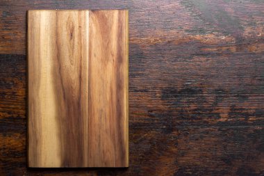 Cutting board on wood kitchen table. Food recipe concept at wood background texture with copy space. Top view.