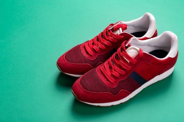 Yeşil arka planda yeni markasız koşu ayakkabısı ya da antrenör. Erkek spor ayakkabıları. Bir çift spor ayakkabı. Metin için boşluk.