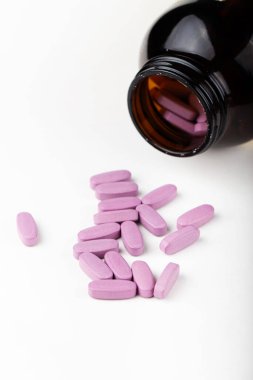 İlaç şişesinden dökülen pembe ilaç ve haplar. Antidepresan ilaçlar. Metin için boşluk.