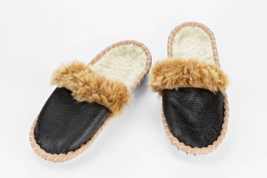 Beyaz arka planda sıcak terlikler. Gerçek deriden yapılmış ev ayakkabıları..