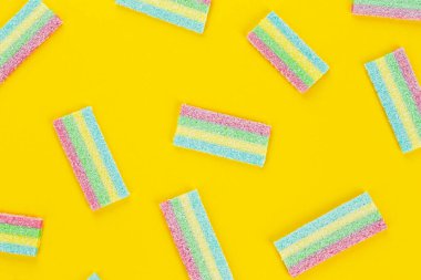 Meyan kökü şekeri. Sarı arka planda farklı aromalı tatlı jelibonlar. Üst görünüm.