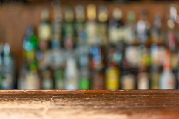 Empty wooden bar counter with defocused background and bottles of restaurant, bar or cafeteria background .For your product display.