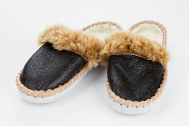 Beyaz arka planda sıcak terlikler. Gerçek deriden yapılmış ev ayakkabıları..