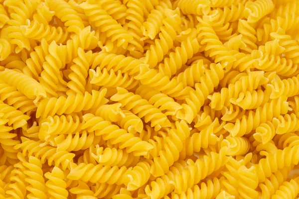 Close-up of raw pasta, texture or background Fusilli. Raw and Dry Macaroni. Italian Culture. Top view.