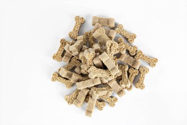 Beyaz arka planda kemik şeklinde kuru köpek maması. Üst görünüm.