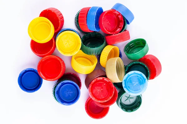Plastic bottle caps on white background. Cap material is recyclable. Recycling collection and processing plastic bottle caps. Remove lids from plastic bottles before recycling them.