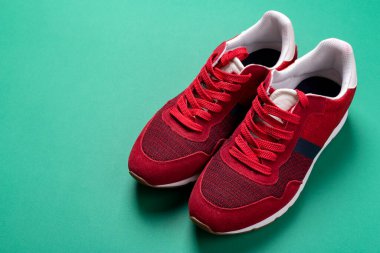 Yeşil arka planda yeni markasız koşu ayakkabısı ya da antrenör. Erkek spor ayakkabıları. Bir çift spor ayakkabı. Metin için boşluk.