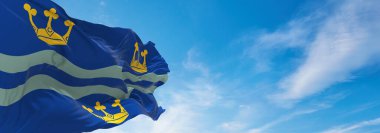 Cambridgeshire ilçesi bayrağı, Birleşik Krallık günbatımında bulutlu bir arka plan, panoramik manzara. Büyük Britanya Birleşik Krallığı, İngiltere. Geniş afiş afiş için kopyalama alanı, 3d illüstrasyon