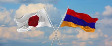 Japonya ve Ermenistan 'ın bayrakları rüzgarda dalgalanırken bayrak direkleri gökyüzüne karşı güneşli bir günde bulutlarla. İki ülke arasındaki ilişkiyi, diyaloğu sembolize ediyor. 3d illüstrasyon,