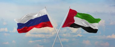 Rusya ve Birleşik Arap Emirlikleri 'nin bayrakları güneşli bir günde gökyüzüne karşı bayrak direkleri sallıyor. İki ülke arasındaki ilişkiyi, diyaloğu sembolize ediyor. 3d illüstrasyon,
